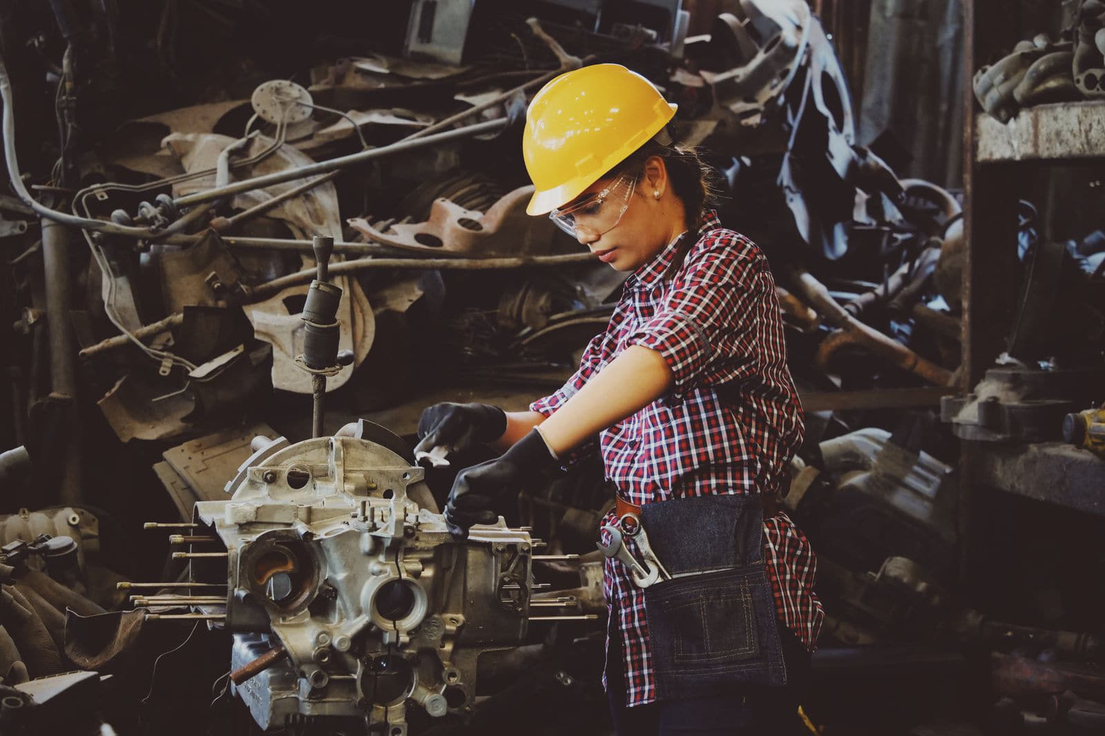 Plant technician in protective gear working on industrial equipment